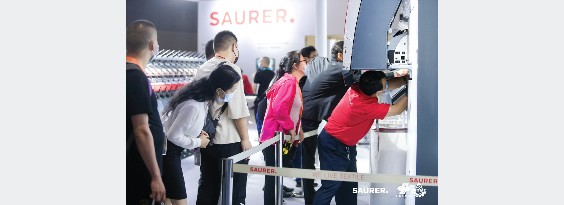 Saurer ITMA Asia employee leaning into machine